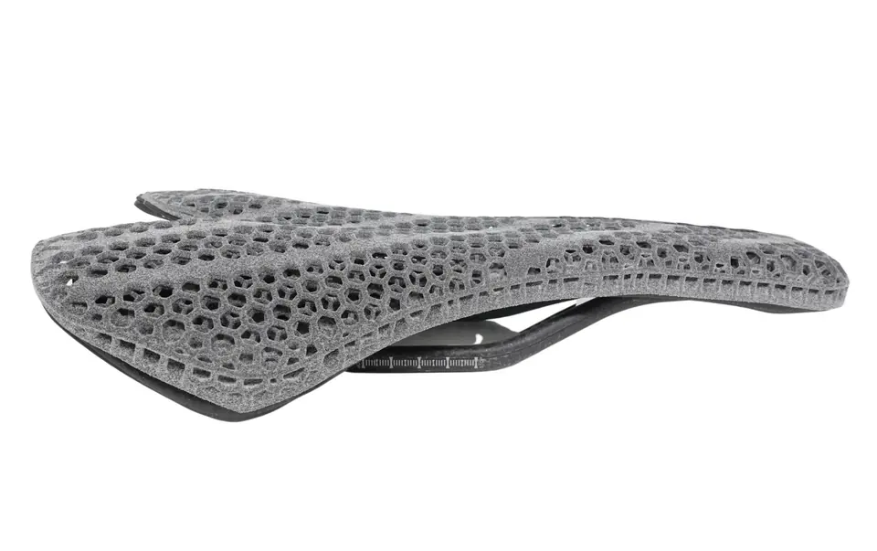 3D-printed lattice bicycle saddle as printed, with a rough grey surface