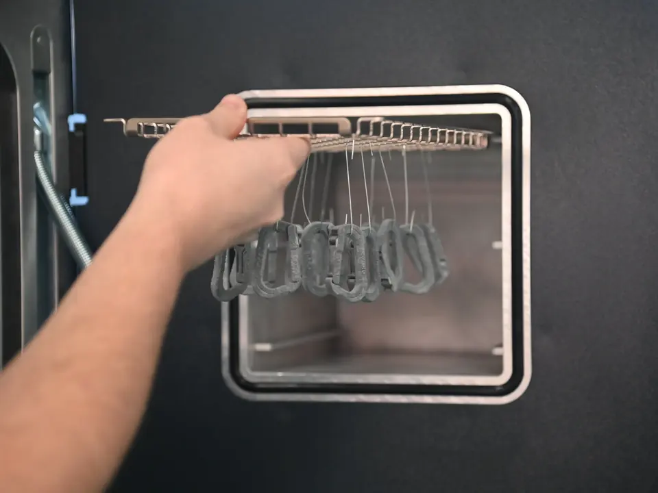 The loaded rack sliding into the chamber of a PostPro vapor smoothing system