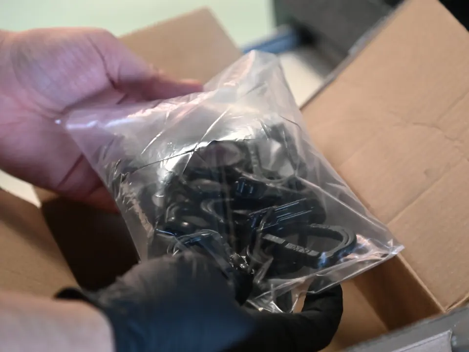 A bag of the parts after vapor smoothing, now black and glossy, packed to ship back