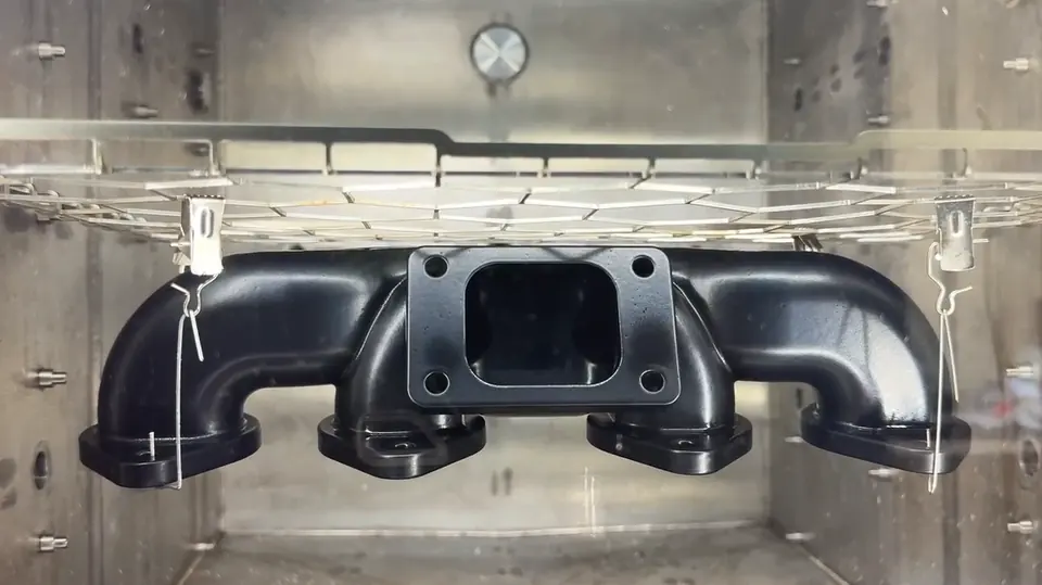 The same manifold after a vapor smoothing cycle, with a sealed, glossy black surface