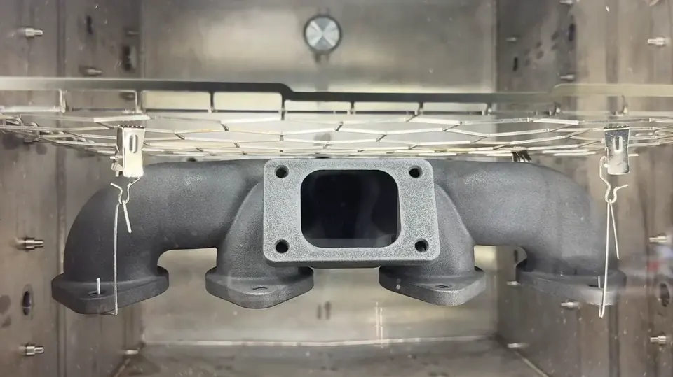 AMT demo manifold hanging in a PostPro SF chamber before vapor smoothing, with a matte grey printed surface